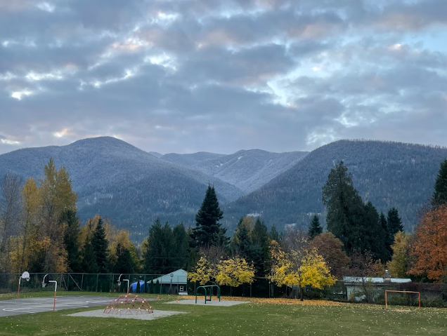 A park with trees and mountains in the background</p>
<p>Description automatically generated