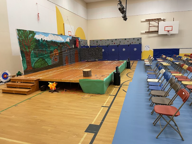 A room with a stage and chairs

Description automatically generated