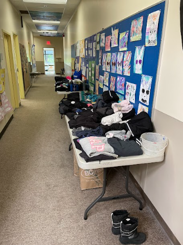 A long hallway with a table with clothes on it
Description automatically generated